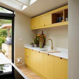 a modern yellow kitchen with white worktop