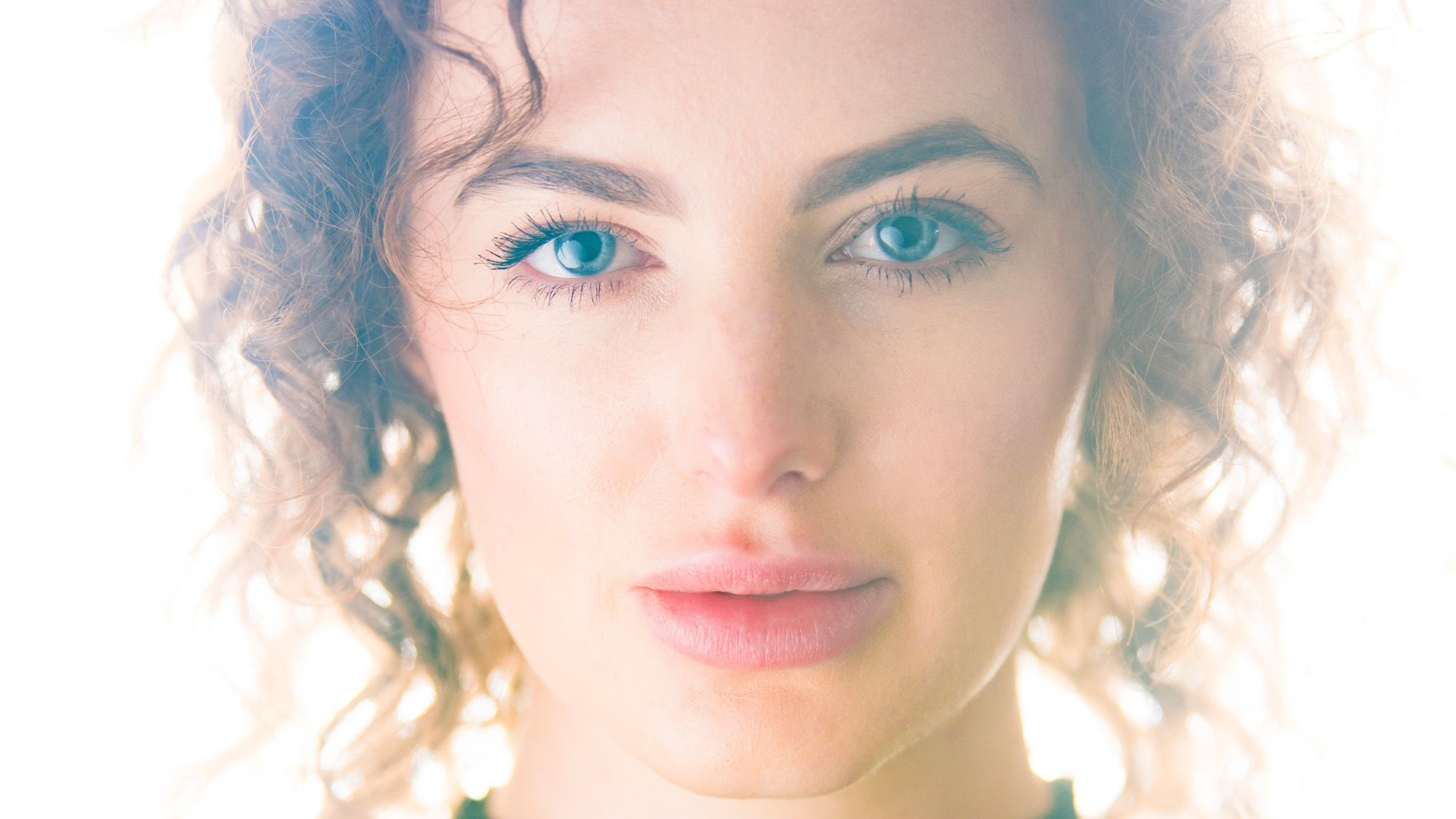 Close-up studio portrait of model by James Paterson on a white background