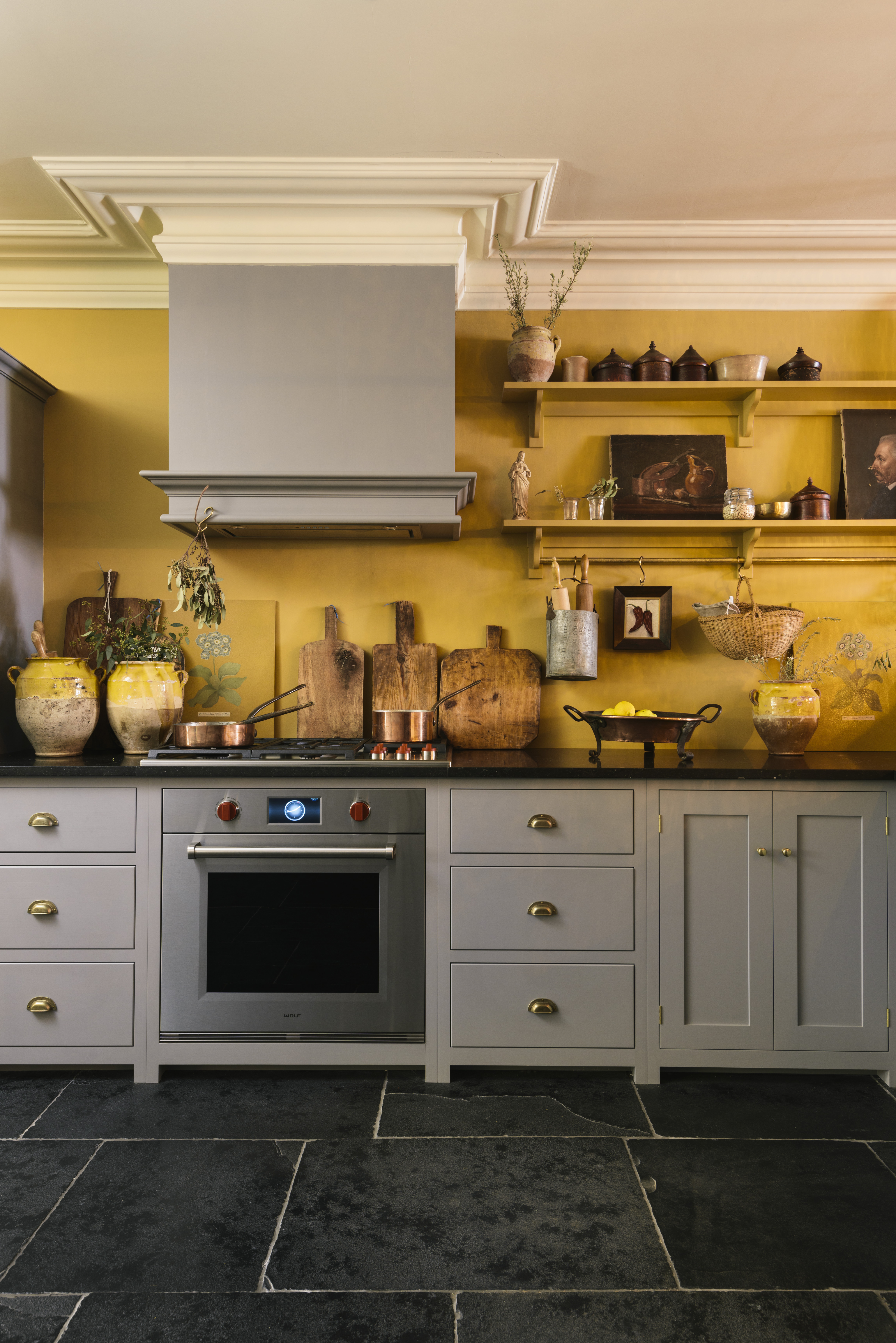 A kitchen with bright yellow walls and grey cabinets