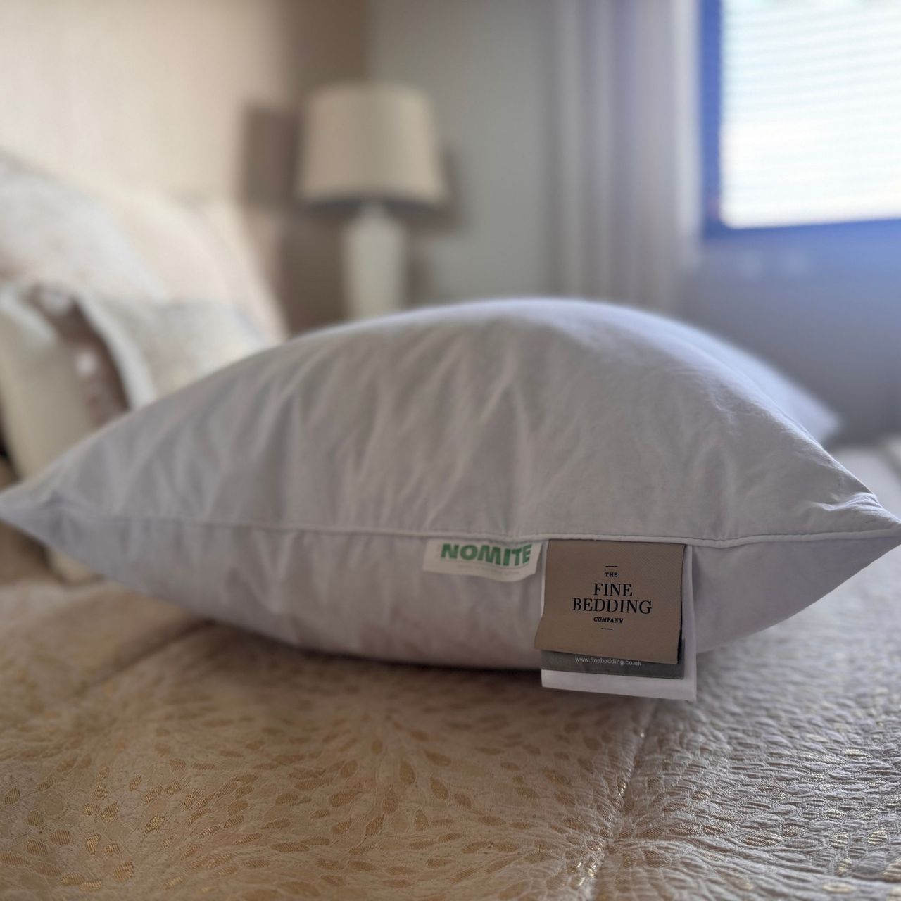 The Goose Down Surround Pillow from The Fine Bedding Company, pictured on a tester's bed