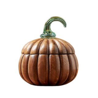 A dark brown wooden pumpkin candle vessel with a dark green glass stem