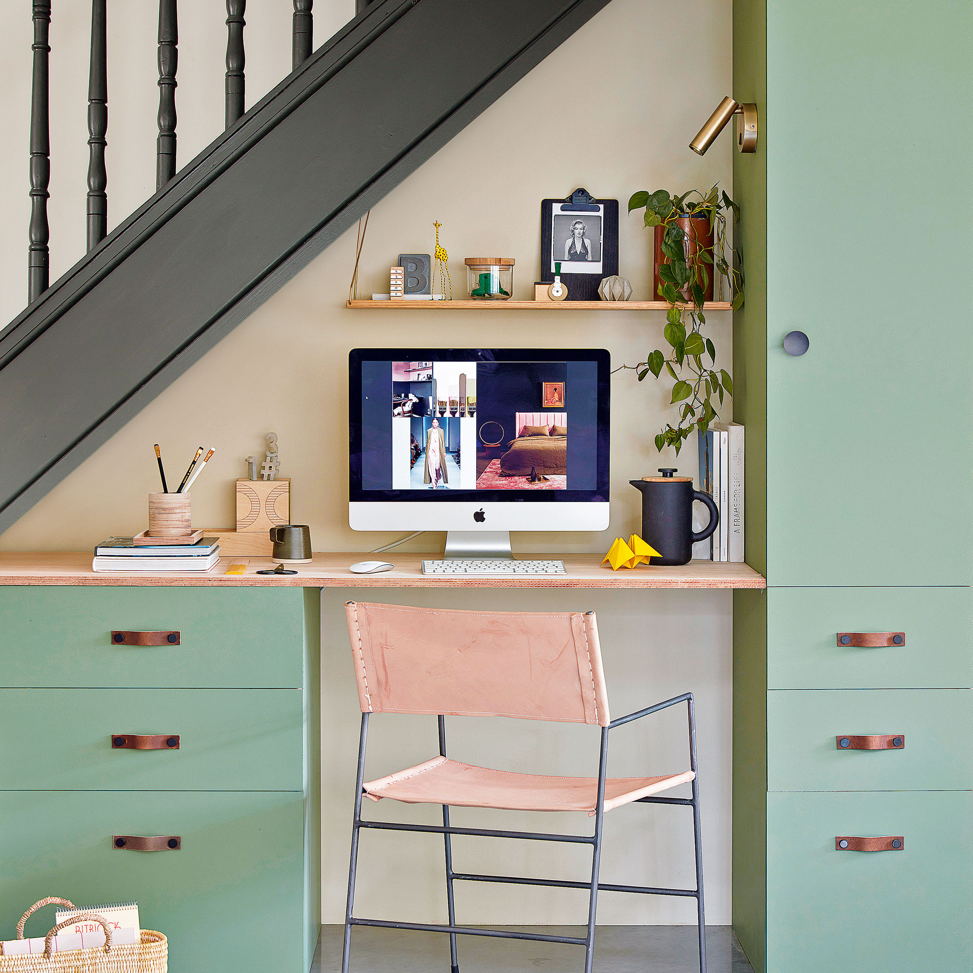 Under the stairs desk with gold spotlight mounted on the wall