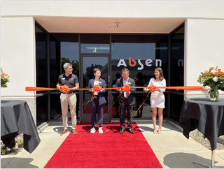 Absen employees stand at the red ribbon at its new LA office grand opening.