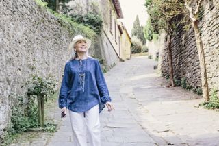 Stylish mature woman strolling on cobbled street, Fiesole, Tuscany, Italy - stock photo