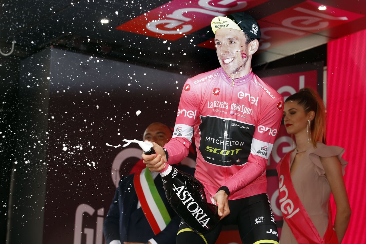 Simon Yates sprays another bottle of champagne on the podium