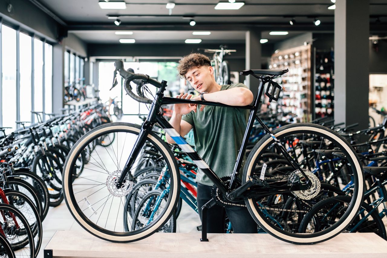 Young man checking out at new bicycle in bikeshop