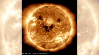 Three dark coronal holes make the sun appear as though it's smiling in this satellite image.
