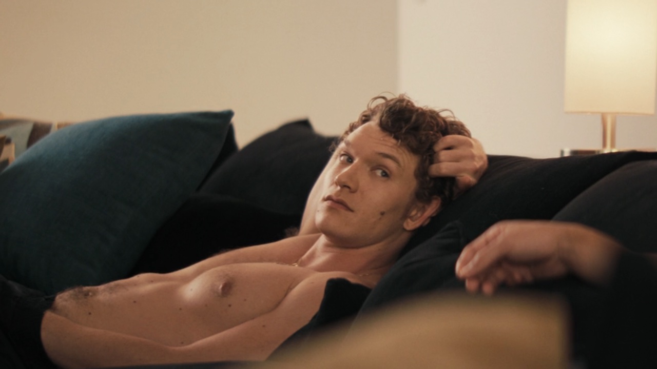 イリヤはソファでズボンに手を下げながらシェーンと話しています。