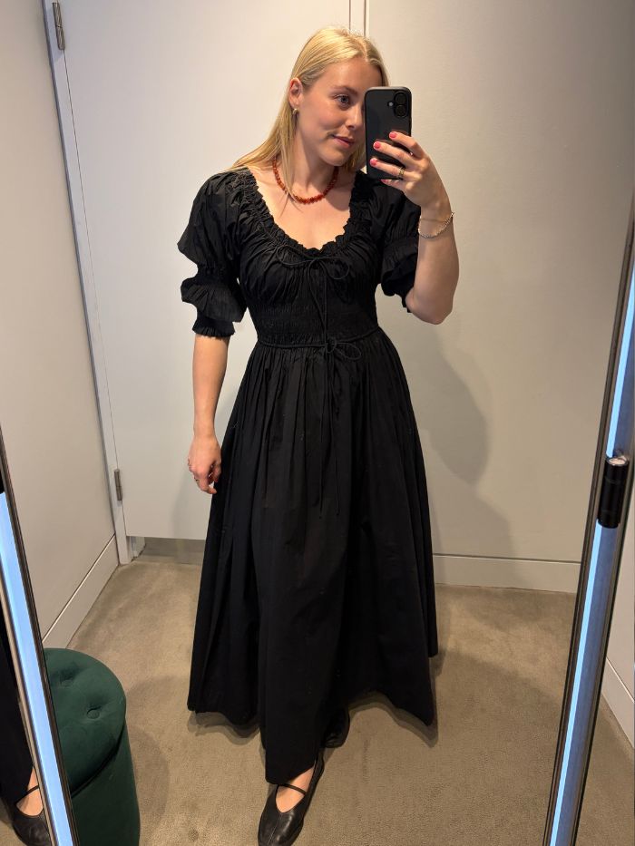 Woman wears black Doen dress with black ballet flats