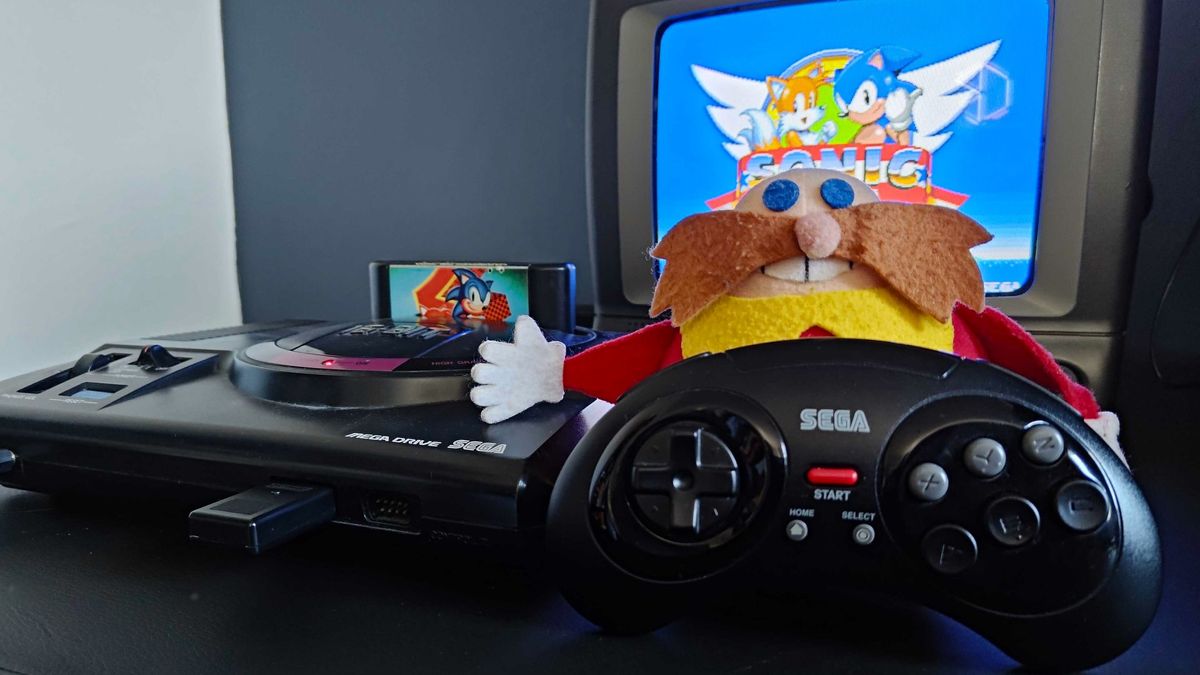 Retro-bit wireless Genesis controller next to Dr Eggman plush, Japanese Sega Mega Drive, and old CRT TV with Sonic 2 on screen