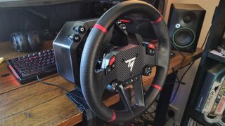 The Thrustmaster T598 direct drive racing wheel attached to a desk with the included mounts