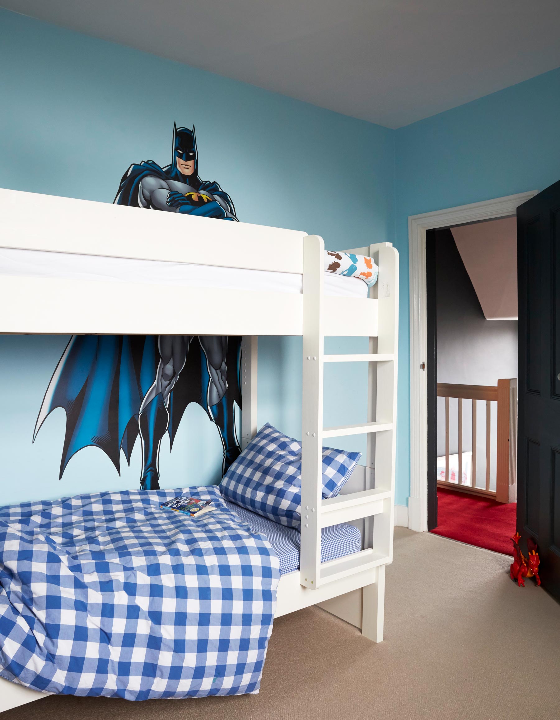 Blue boys bedroom with bunk beds and bat man wall sticker