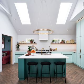 Blue kitchen renovation with circular light and island