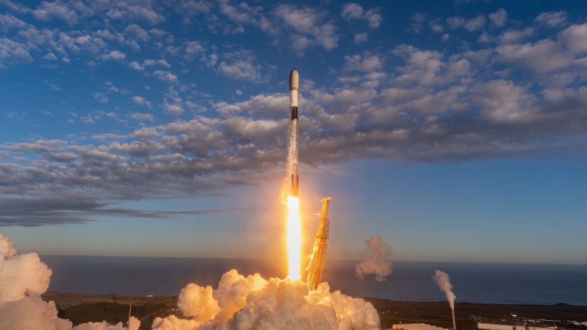 A black and white SpaceX satellite launches Starlink satellites from a seaside launch pad.