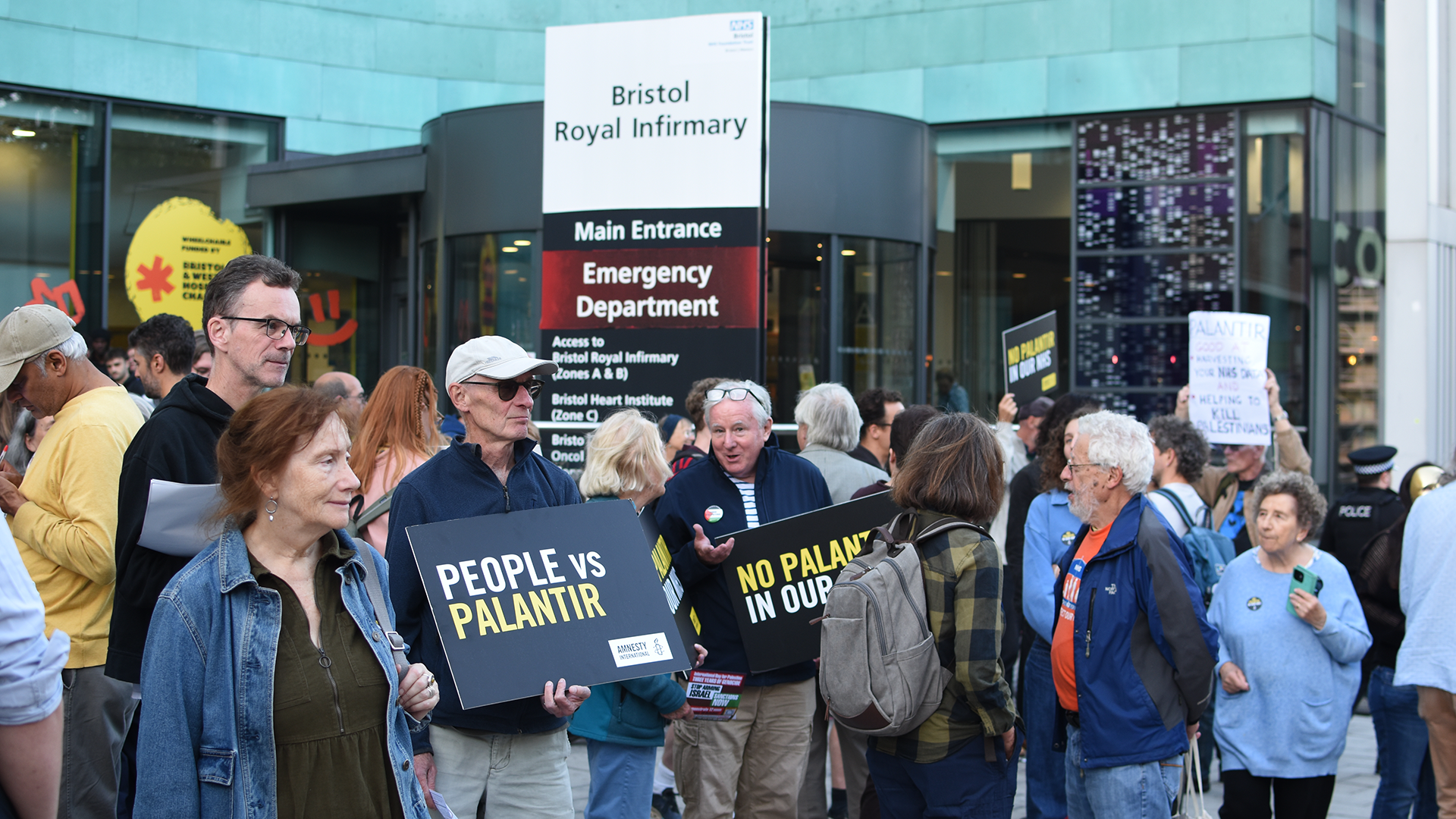 People holding placards against Palantir in the NHS in front of the Bristol Royal Infirmary during a protest on October 1, 2026