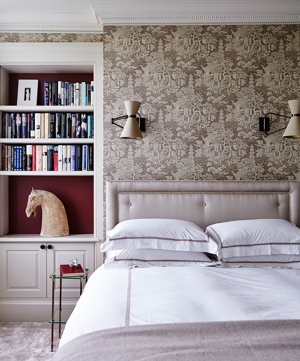 Alcove bookshelves and a gray upholstered bed illustrating small bedroom storage ideas.