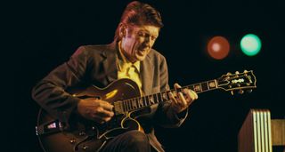 Jazz great Tal Farlow plays his Gibson hollowbody onstage at Newport, wincing as he plays a run