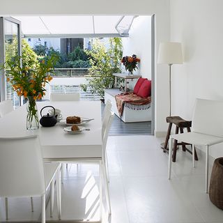 white kitchen with table and chair and ceramic floor tiles