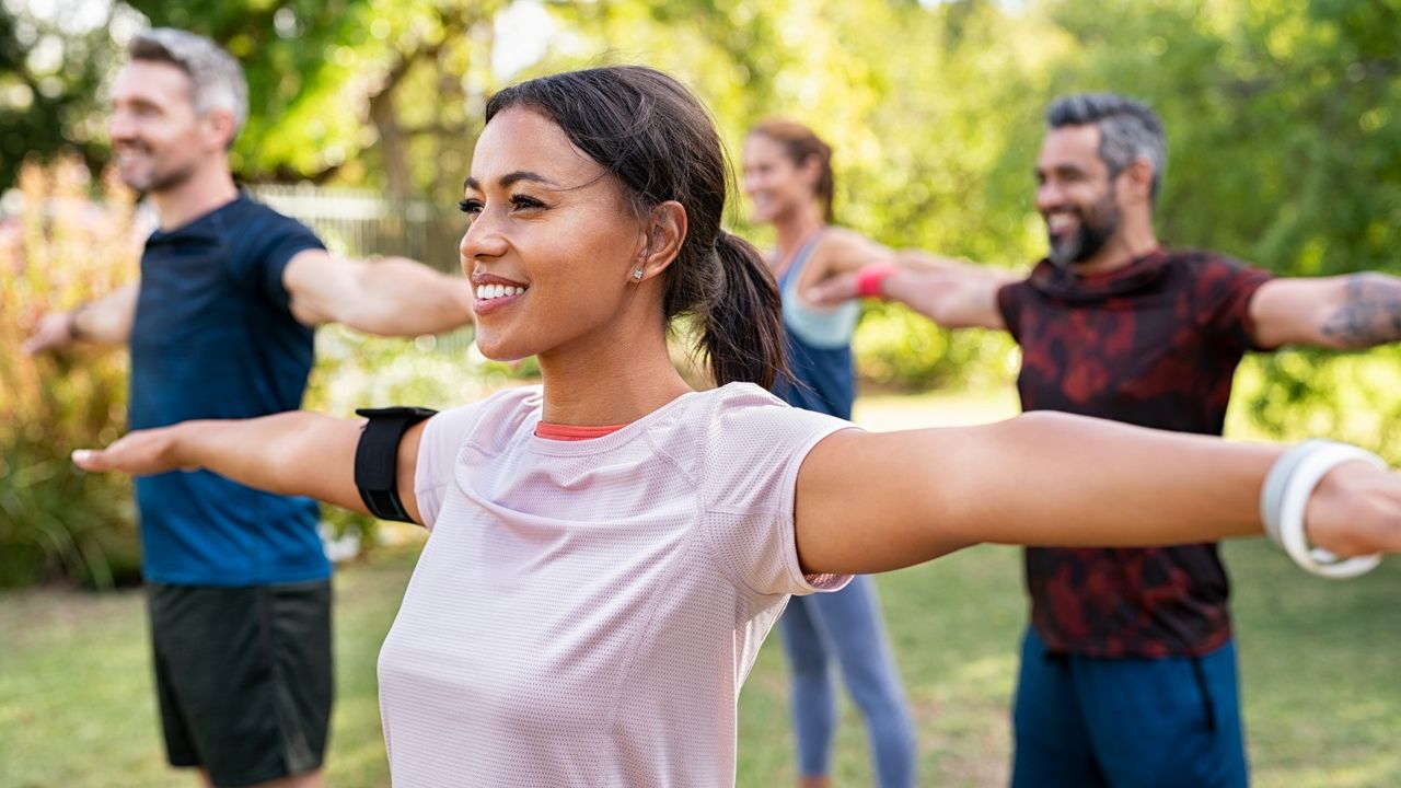 Group of people stretching arms outdoors