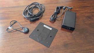 A power cable, power adapter, VESA mount, and external power button that comes with the MSI Cubi NUC 13MQ.