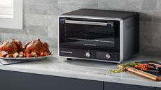 Toaster vs Toaster Oven - KitchenAid Toaster Oven on a countertop with a chicken on the left hand side of it
