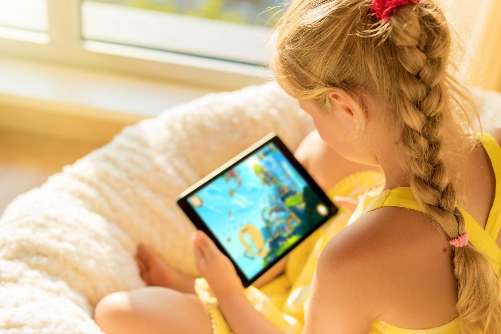 A child plays a mobile game on the tablet