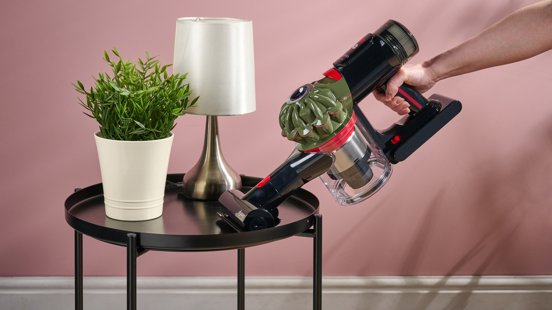 Dyson V8 Cyclone in handheld mode, with Mini motorized attachment, cleaning a side table