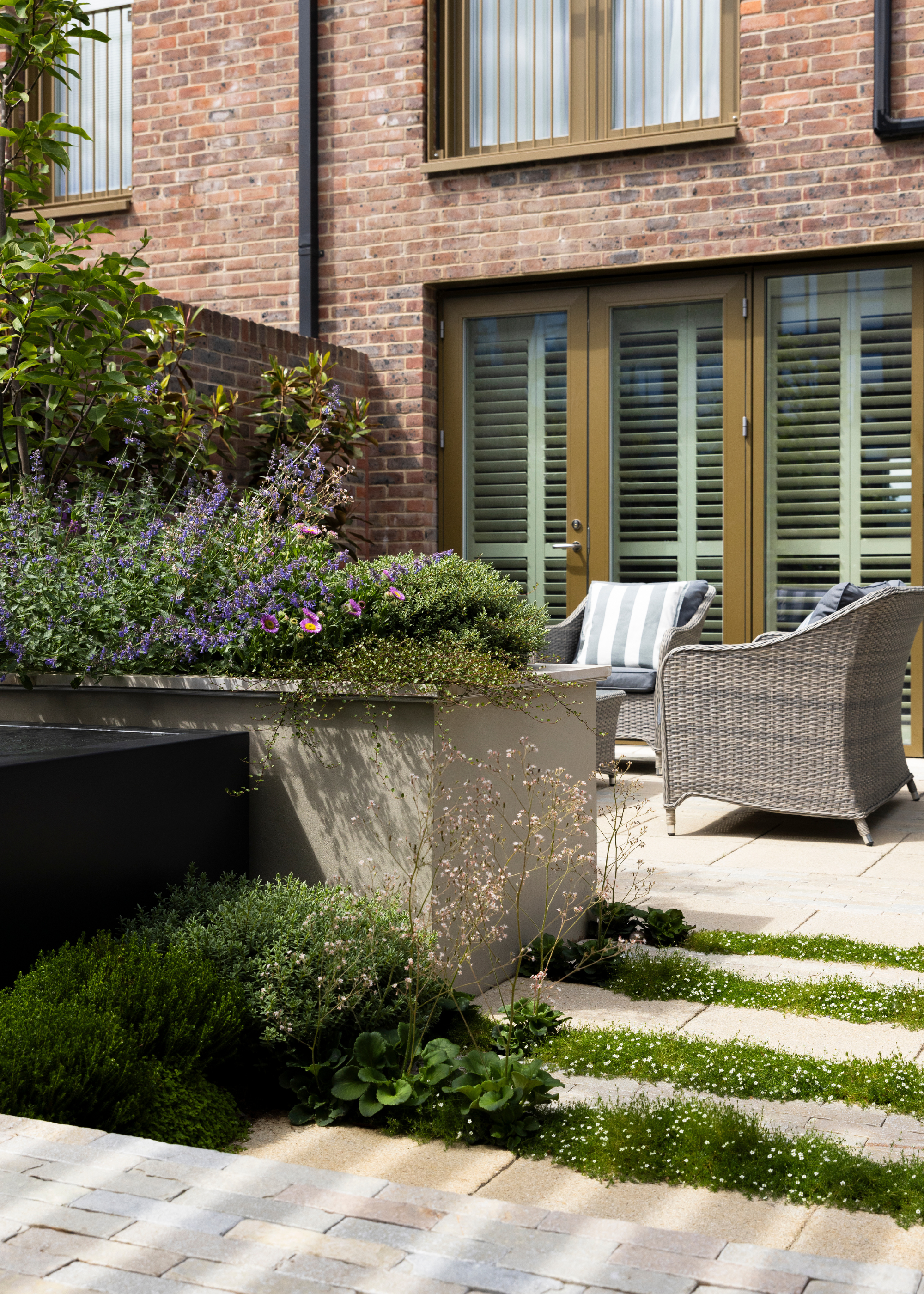 modern bento garden design with paved flooring and tall concrete planters