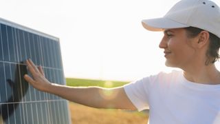 female placing hand on solar panel