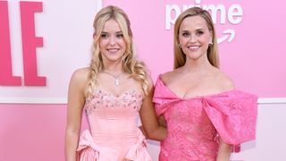 Lexi Minetree and Reese Witherspoon both wear pink for the carpet for Elle's premiere. Both have their arms around each others' backs.