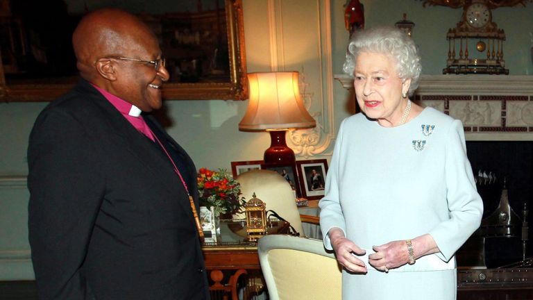 Britain's Queen Elizabeth II welcomes South African Reverend Desmond Tutu at Buckingham Palace in central London on November 20, 2013. 
