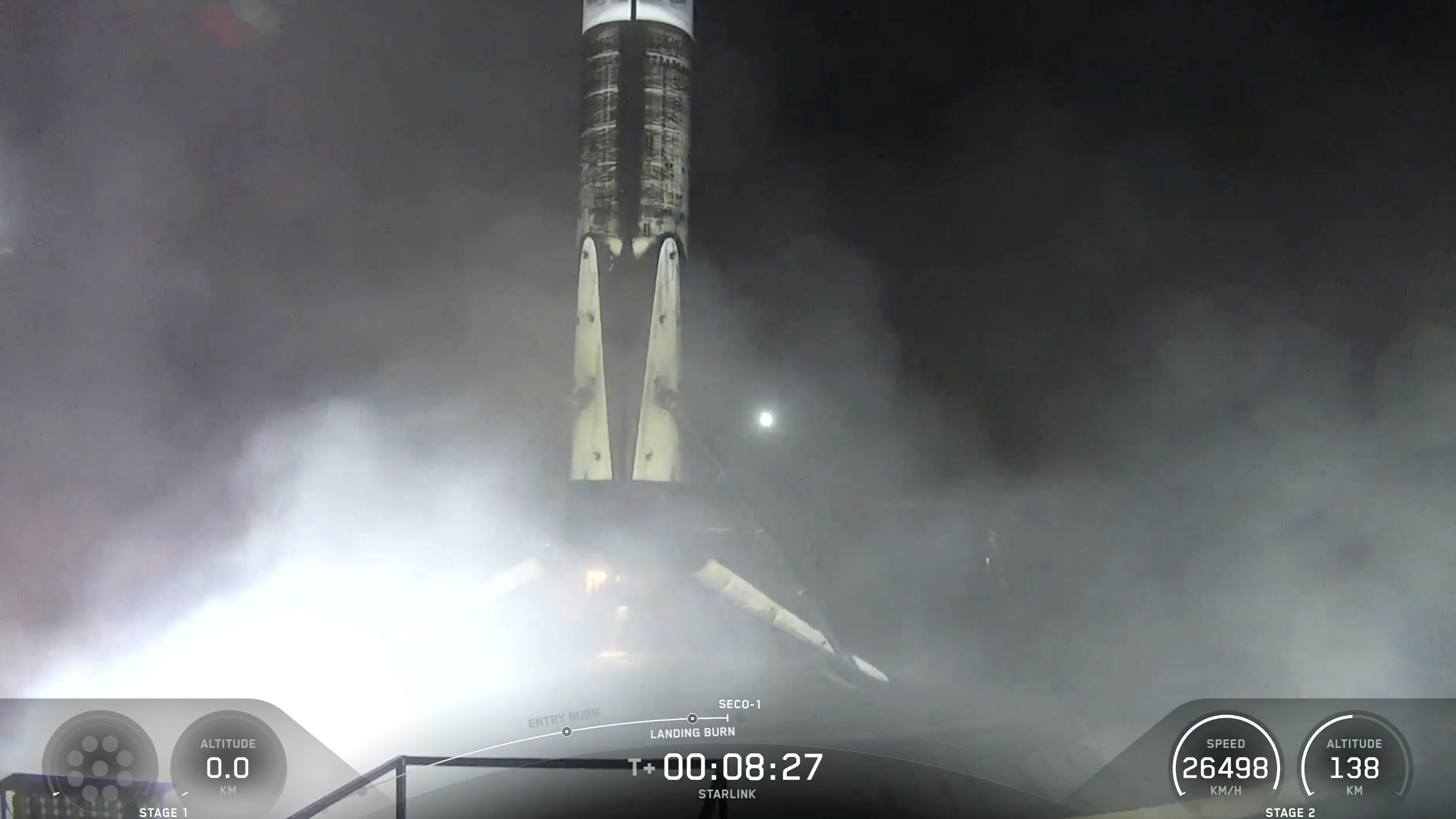 A black and white spacex falcon 9 rocket first stage sits on the deck of a ship at sea.