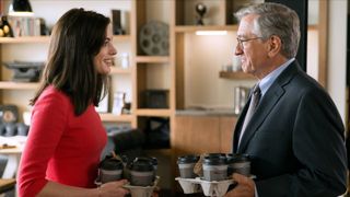 Anne Hathaway and Robert De Niro holding coffee carriers in The Intern