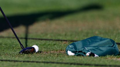 Close up of a putter, a golf ball and a bag