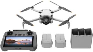 DJI Mini 4 Pro drone on white background with controller and spare batteries