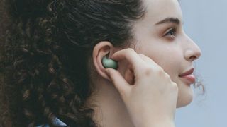 Sony LinkBuds Fit in green, in a woman's ear