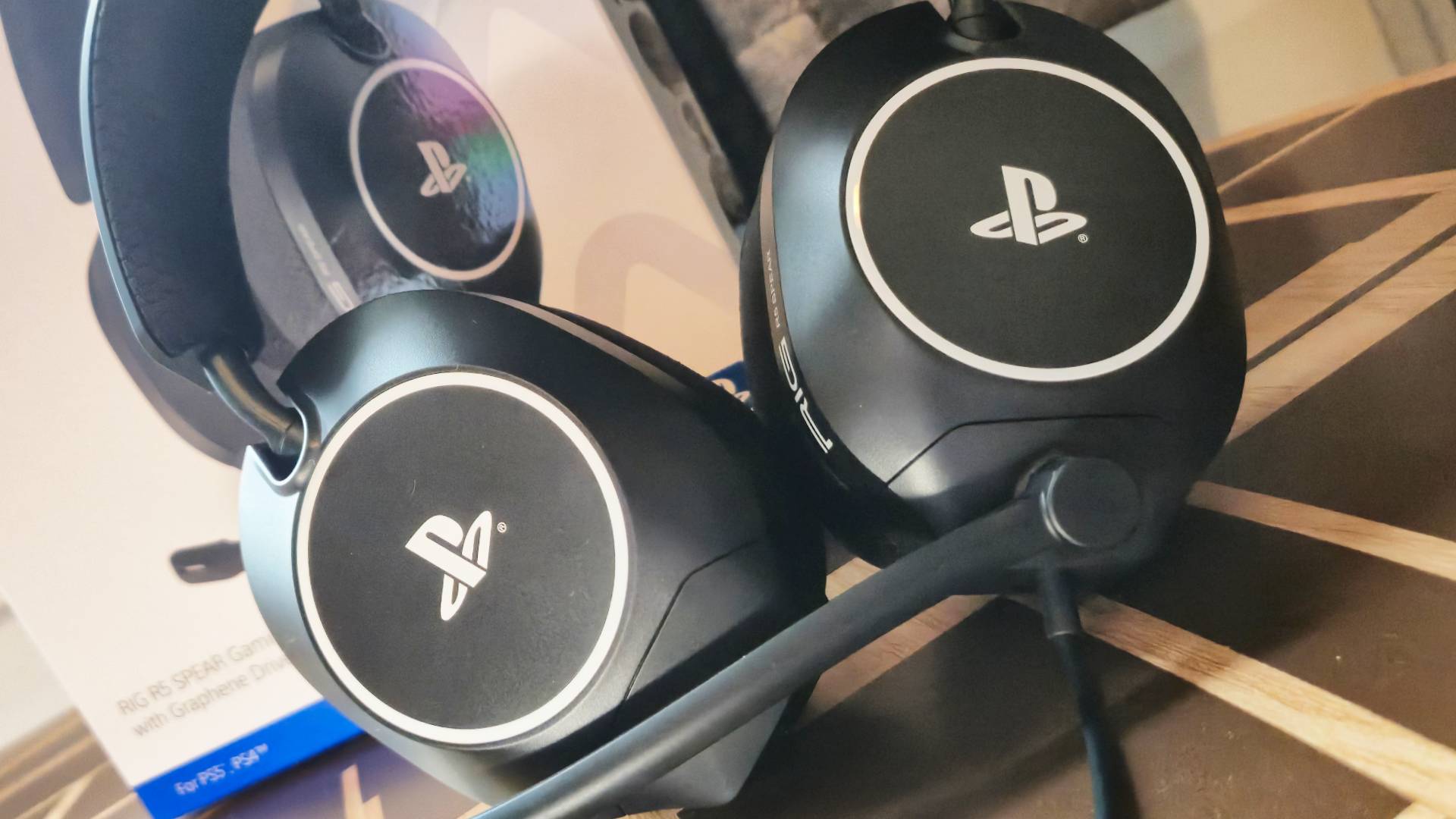 Photo of a black headset with white Sony PlayStation logos printed on the outer cups.