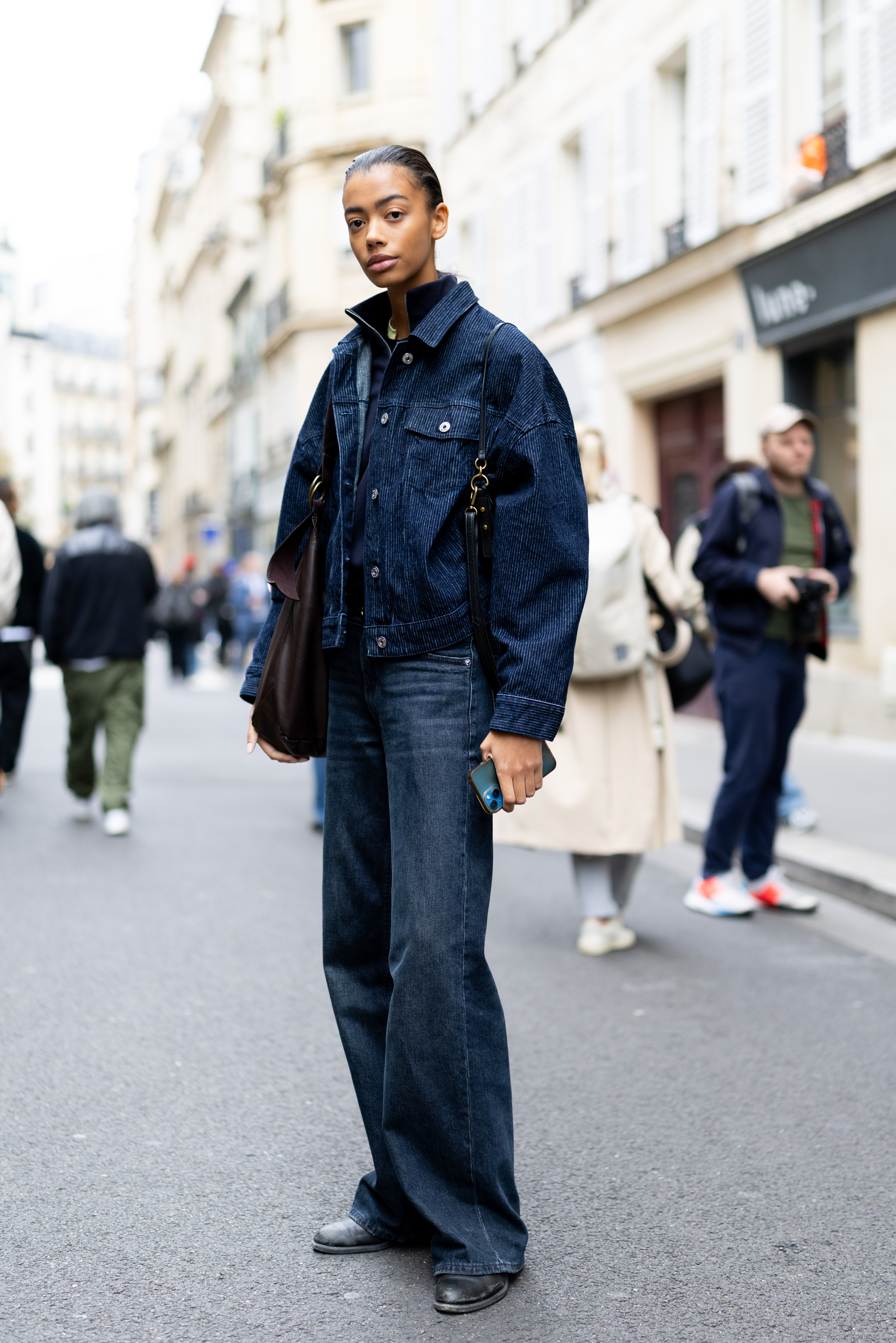 Person wearing a denim jacket during Paris Fashion Week.