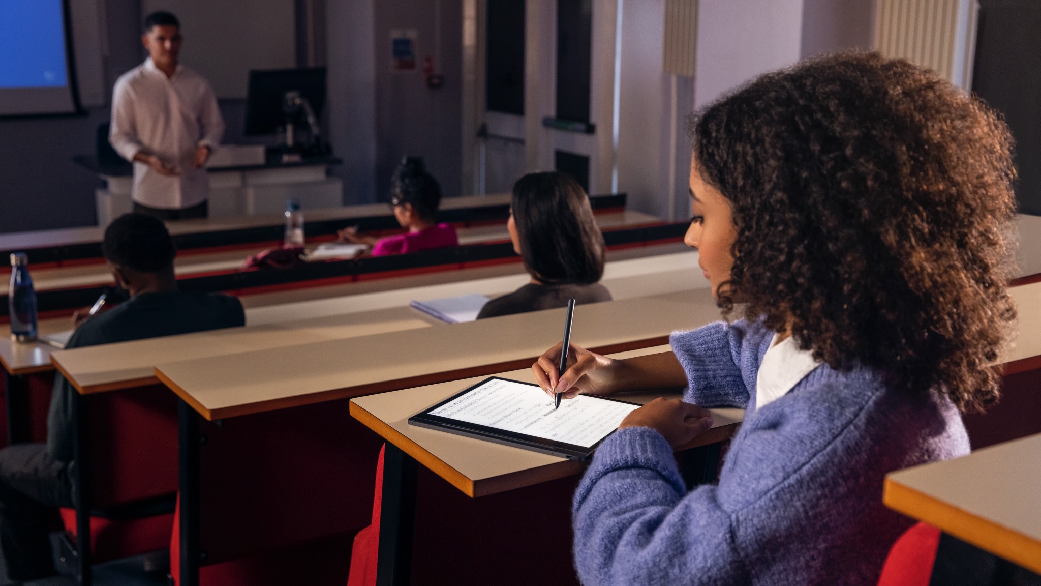 Uma jovem usa o tablet e-ink Lenovo Smart Paper em uma sala de aula.