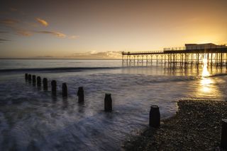 Bognor Regis pier in the sunlight, with the sea in the foreground