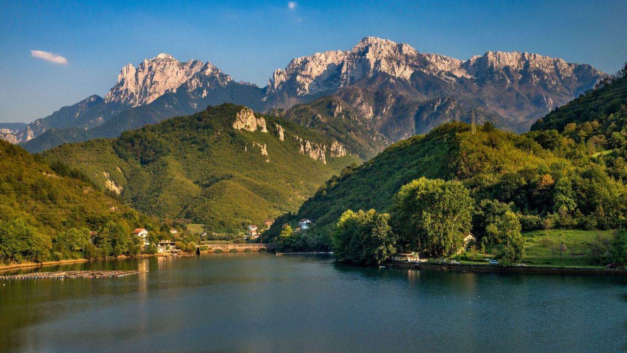 a landscape photo of a lake at the foot of a mountain