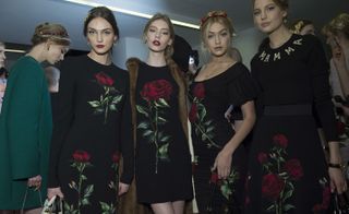 Models wearing black dresses with floral prints and golden hairpiece elements, from Dolce & Gabbana A/W 2015 collection.