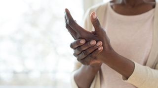 A close up image of a pair of hands - one massaging the other