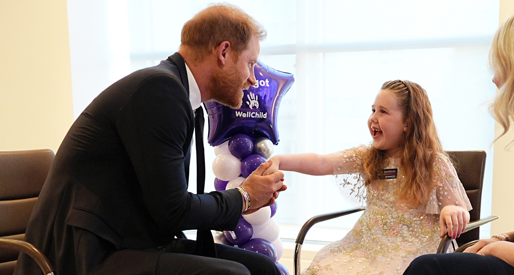Prince Harry shaking hands with a little girl at the WellChild Awards
