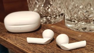 The Denon AH-C500W buds next to the case.