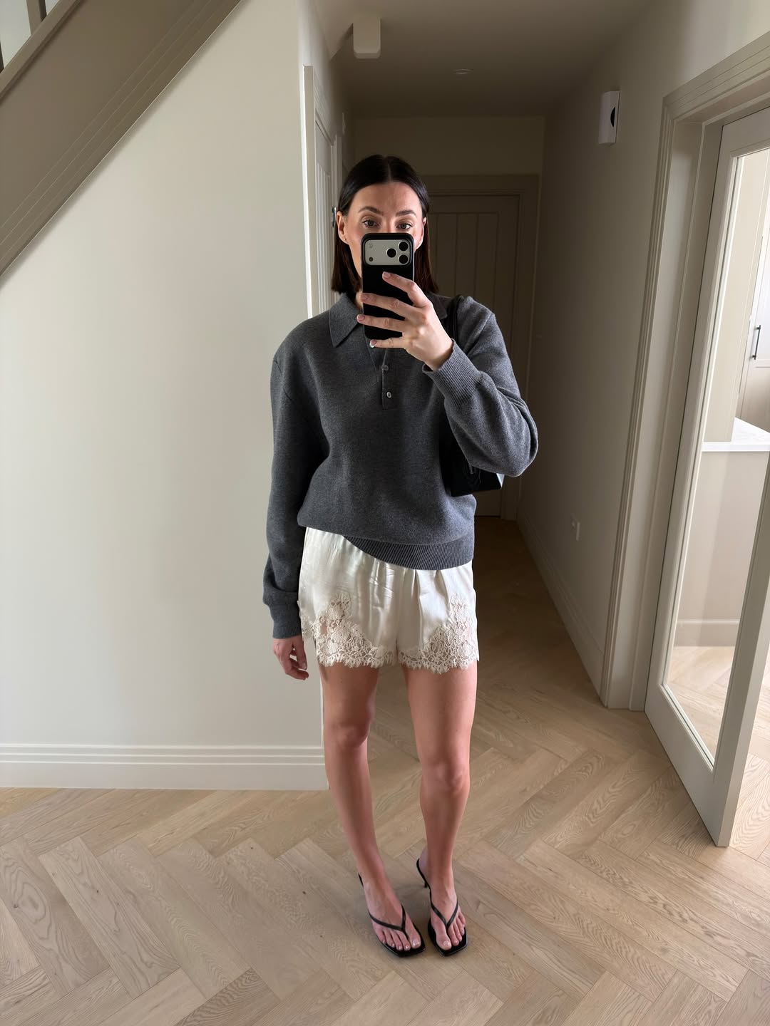 A woman wearing sweater and lace shorts, one of the biggest 2026 spring to summer transitional trends.