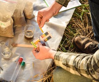 Scientist test pH of soil in a field laboratory