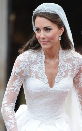 close up of kate middleton, showing the lace neckline and sleeves as well as her tiara and her diamond earrings