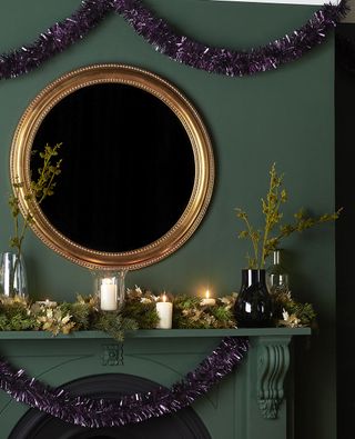 room with golden round mirror on green wall and purple tinsels