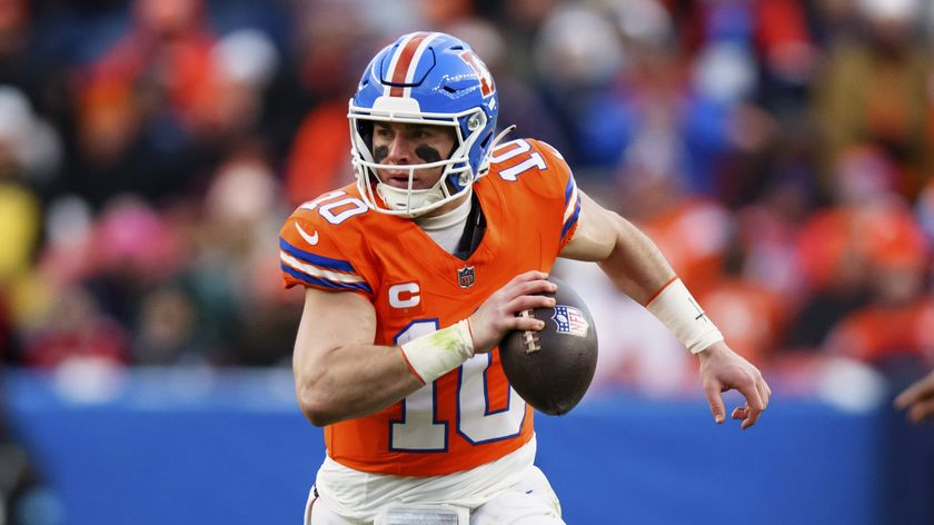  Quarterback Bo Nix #10 of the Denver Broncos runs with the football ahead of the Broncos vs Bills NFL Wildcard showdown.